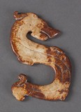 A carved chicken bone jade dragon ornament