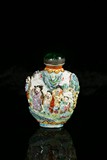 A FAMILLE ROSE MOULDED ‘EIGHT IMMORTALS’ SNUFF BOTTLE