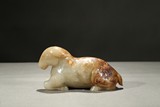 A CELADON AND RUSSET JADE CARVING OF RAM