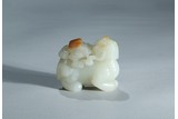 A WHITE JADE WITH RUSSET SKIN CARVED MYTHICAL BEAST
