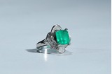 AN EMERALD AND DIAMOND WHITE GOLD RING