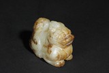 A WHITE AND RUSSET JADE CARVING OF MYTHICAL ANIMAL