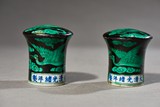 PAIR OF GREEN GLAZED BLACK GROUND PAINTING SCROLL HEADS