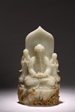 A WHITE JADE CARVED BUDDHA AND ATTENDANTS