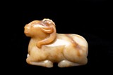 A CHINESE RUSSET AND WHITE JADE RAM