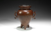 A BRONZE TRIPOD TWO HANDLE CENSER