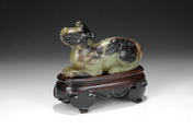 A CELADON JADE CARVED MYTHICAL BEAST