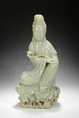 A CARVED CELADON JADE GUANYIN STATUE