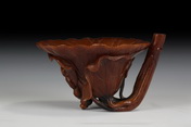 A FINELY CARVED RHINOCEROS HORN 'LOTUS' LIBATION CUP