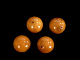 A SET OF FOUR LARGE AMBER BEADS