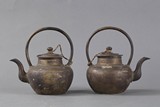 A pair of bronze teapots
