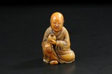 A SHOUSHAN SOAPSTONE FIGURE OF A SEATED LUOHAN 