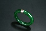 A JADE BANGLE WITH SILVER ENCLOSURE