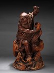 A WOOD CARVED BODHIDHARMA WITH DRAGON STATUE