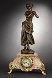 A FRENCH MARBLE MANTLE CLOCK SURMOUNTED BY STATUE