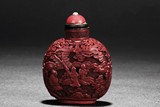 A CARVED CINNABAR LACQUER SNUFF BOTTLE