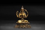 A GILT BRONZE FOUR-ARM GUANYIN FIGURE
