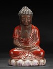 A PAINTED AND GLAZED ZISHA STONEWARE SHAKYAMUNI FIGURE