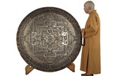 A RARE AND LARGE TIBETAN CARVED SILVER AND GILT MANDALA