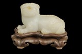 A WHITE JADE CARVING OF MYTHICAL LION FIGURE