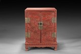 A SMALL CARVED CINNABAR LACQUER CABINET