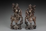 A PAIR OF WOODEN GUANYU ON HORSE CARVINGS INSET WITH SILVER LINES