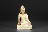 A PAINTED MARBLE CARVED SEATED MONK FIGURE