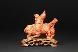 A CORAL CARVED FIGURAL GROUP OF ELDER AND LION
