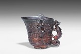 AN AMBER CARVED 'DRAGONS' LIBATION CUP