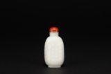 A CARVED WHITE JADE SNUFF BOTTLE