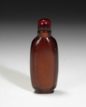 A CARVED BROWNISH GLASS SNUFF BOTTLE