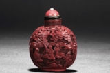 A CARVED CINNABAR LACQUER SNUFF BOTTLE
