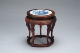 A WOOD CIRCULAR STAND INSET WITH PORCELAIN