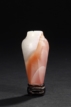 A SMALL PINK AND WHITE AMBER BOTTLE WITH STAND