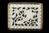 A GILT-BRONZE ENCASED CARVED WHITE JADE BUCKLE