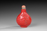 A RED GLAZED CARVED PORCELAIN SNUFF BOTTLE