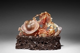 AN AGATE CARVED 'LINGZHI' FIGURAL GROUP WITH HARDWOOD STAND