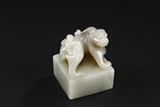 A WHITE AND CELADON JADE 'MYTHICAL BEAST' SEAL