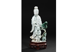A CARVED JADEITE GUANYIN WITH CHILD FIGURE
