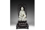 A LARGE WHITE JADE CARVED FIGURE OF GUANYIN WITH ZITAN MANDORLA AND BASE