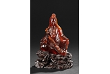 A VERY RARE CARVED AMBER FIGURE OF GUANYIN