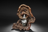 A HARDWOOD TRUNK AND CERAMIC GUANYIN FIGURAL GROUP