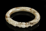 A WHITE AND RUSSET JADE 'DOUBLE DRAGON' BANGLE
