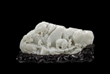 A CARVED WHITE JADE FIGURAL BOULDER 