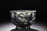 A MOTTLED BLACK AND WHITE JADE LOBED BOWL