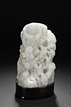 A CARVED WHITE JADE 'LIU HAI AND TOAD' BOULDER