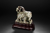 A CELADON AND RUSSET JADE 'ELEPHANT AND BOY' FIGURAL GROUP
