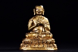 A GILT-BRONZE FIGURE OF LAMA