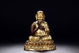 A GILT-BRONZE FIGURE OF LAMA