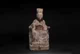 A CARVED WOODEN SEATED OFFICIAL FIGURE